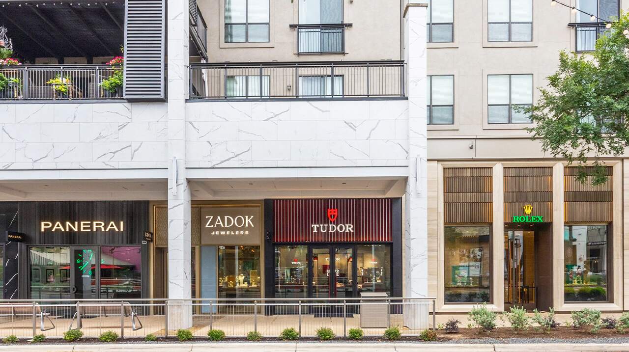 Commercial building with Panerai, Zadok, and Tudor shops on a city street.