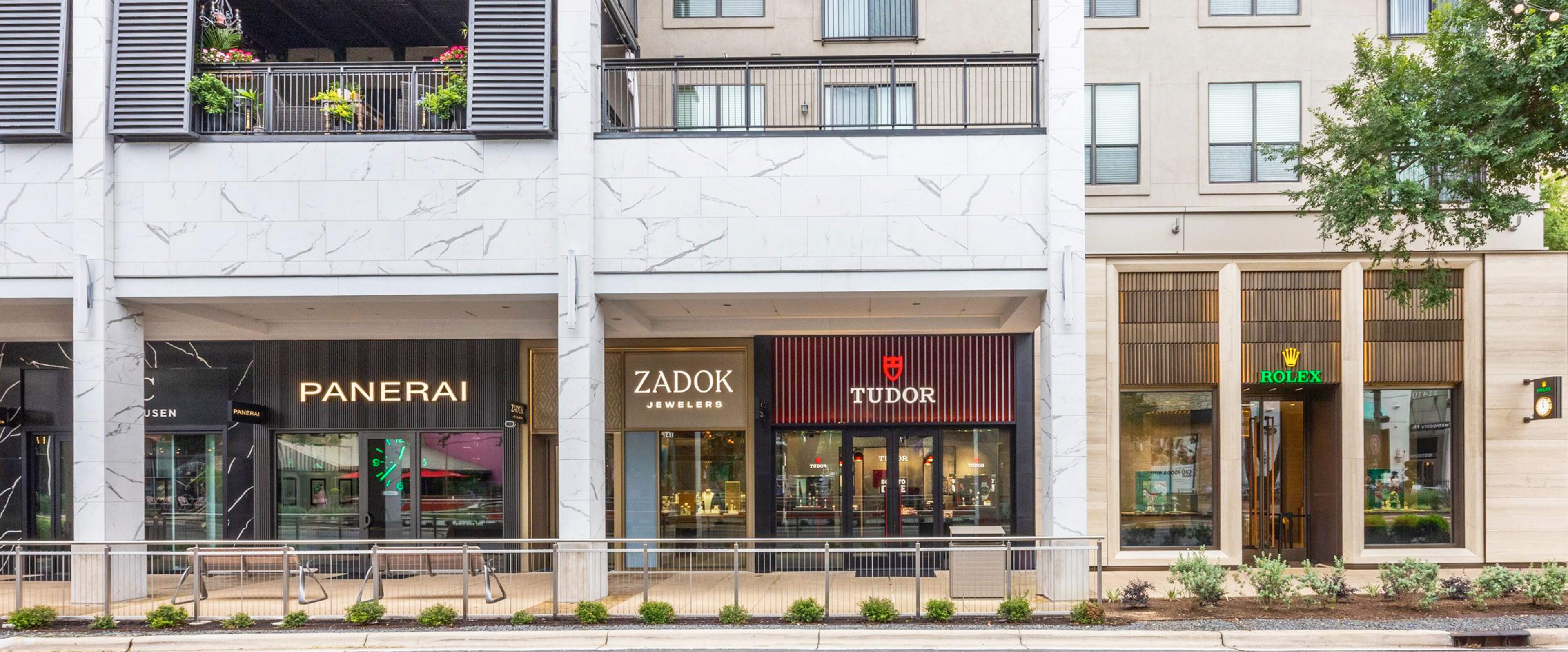 Commercial building with Panerai, Zadok, and Tudor shops on a city street.